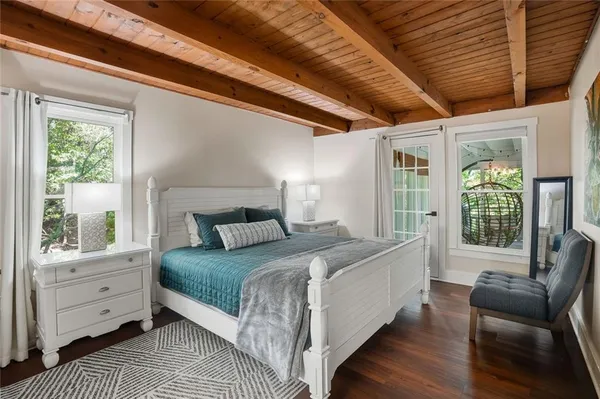 a bedroom with a large bed and windows