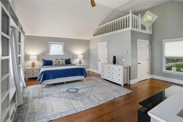 a spacious bedroom with a bed a table and painting on the wall