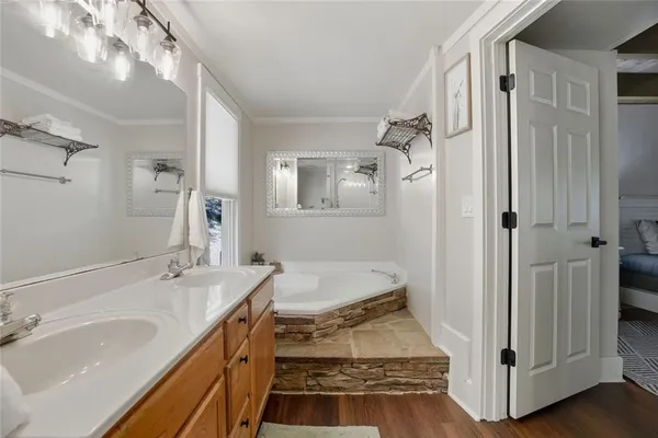 a bathroom with a tub sink and mirror
