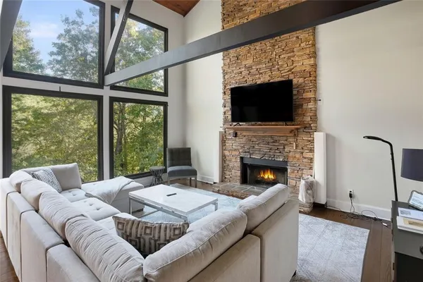 a living room with furniture a fireplace and a floor to ceiling window
