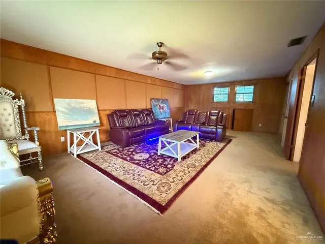 a view of a house with a yard and a large tree