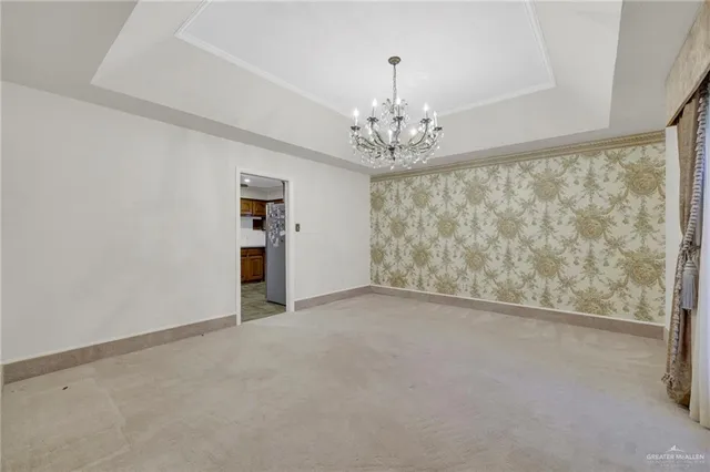 a view of a dining room with furniture and chandelier
