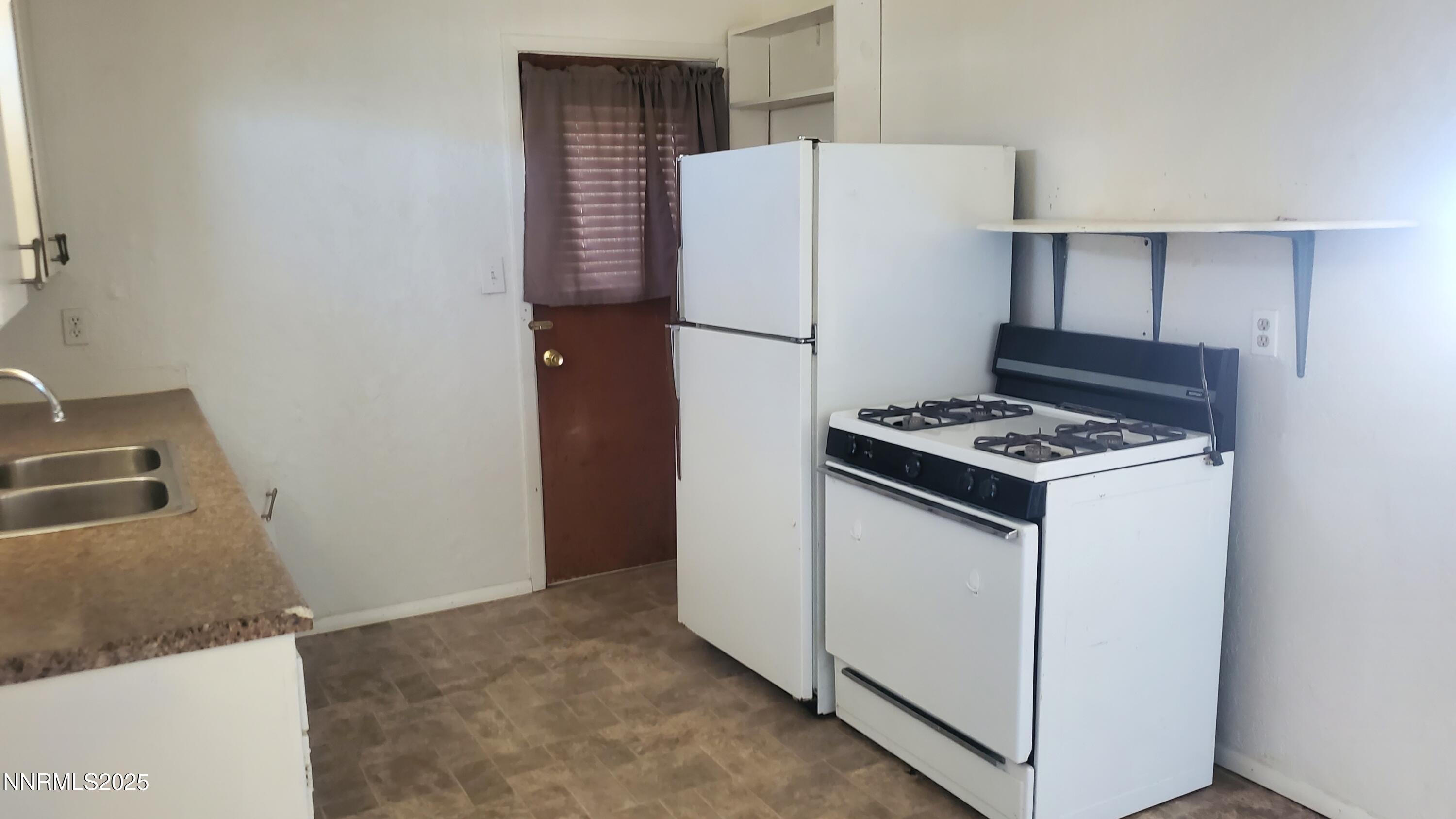 925 Arb Street Hawthorne, NV 89415 - Photo 7 of 10 a white refrigerator freezer and a stove sitting inside of a kitchen