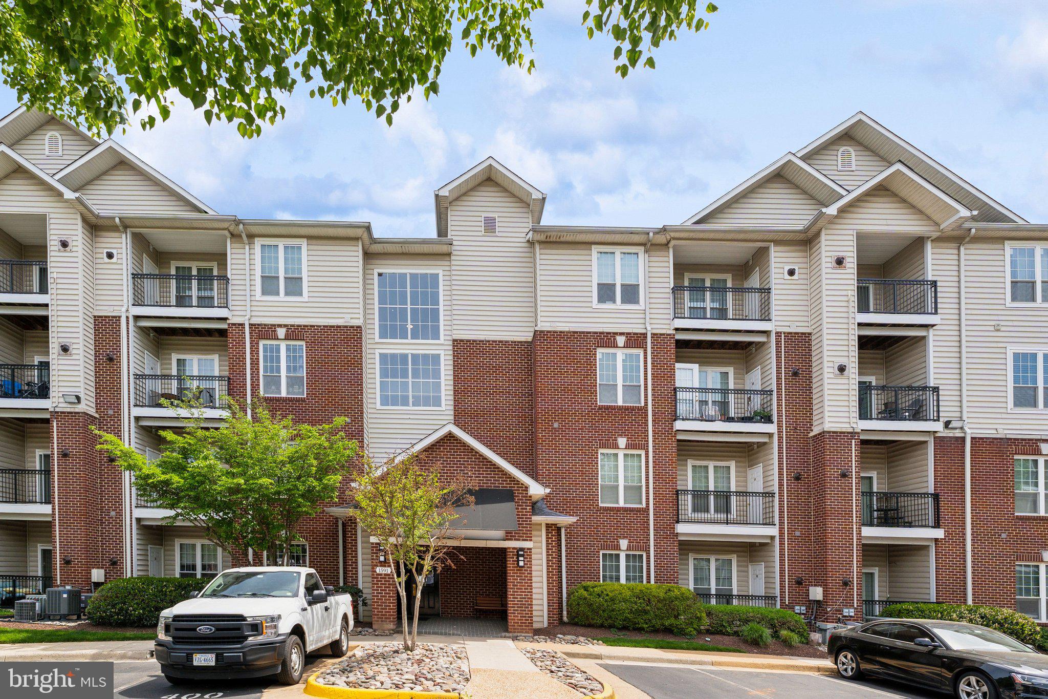 1591 Spring Gate Dr., Unit 3415 McLean, VA 22102 - Photo 2 of 20 a front view of a residential apartment building with a yard