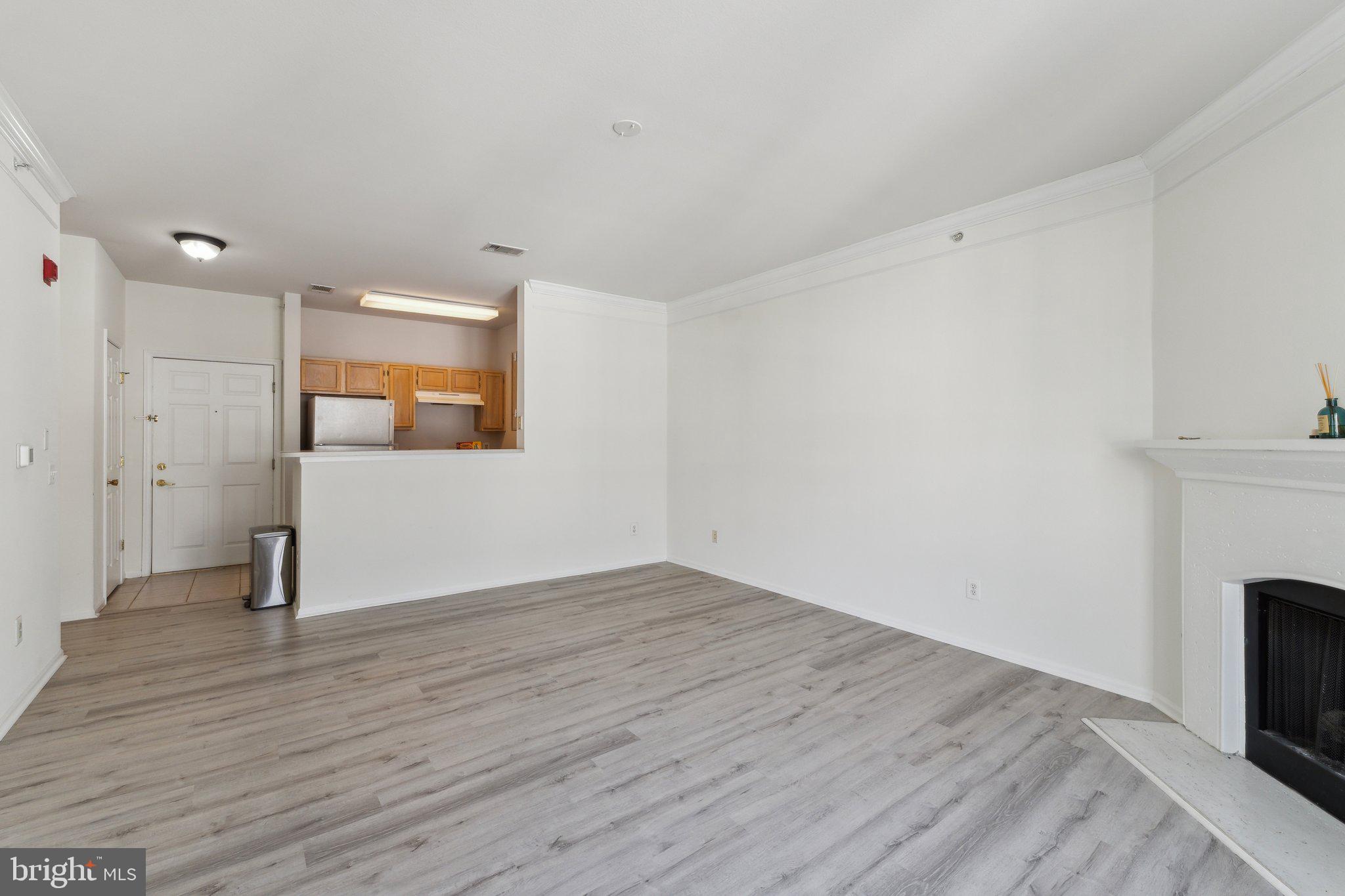 1591 Spring Gate Dr., Unit 3415 McLean, VA 22102 - Photo 7 of 20 a view of empty room with wooden floor and fireplace