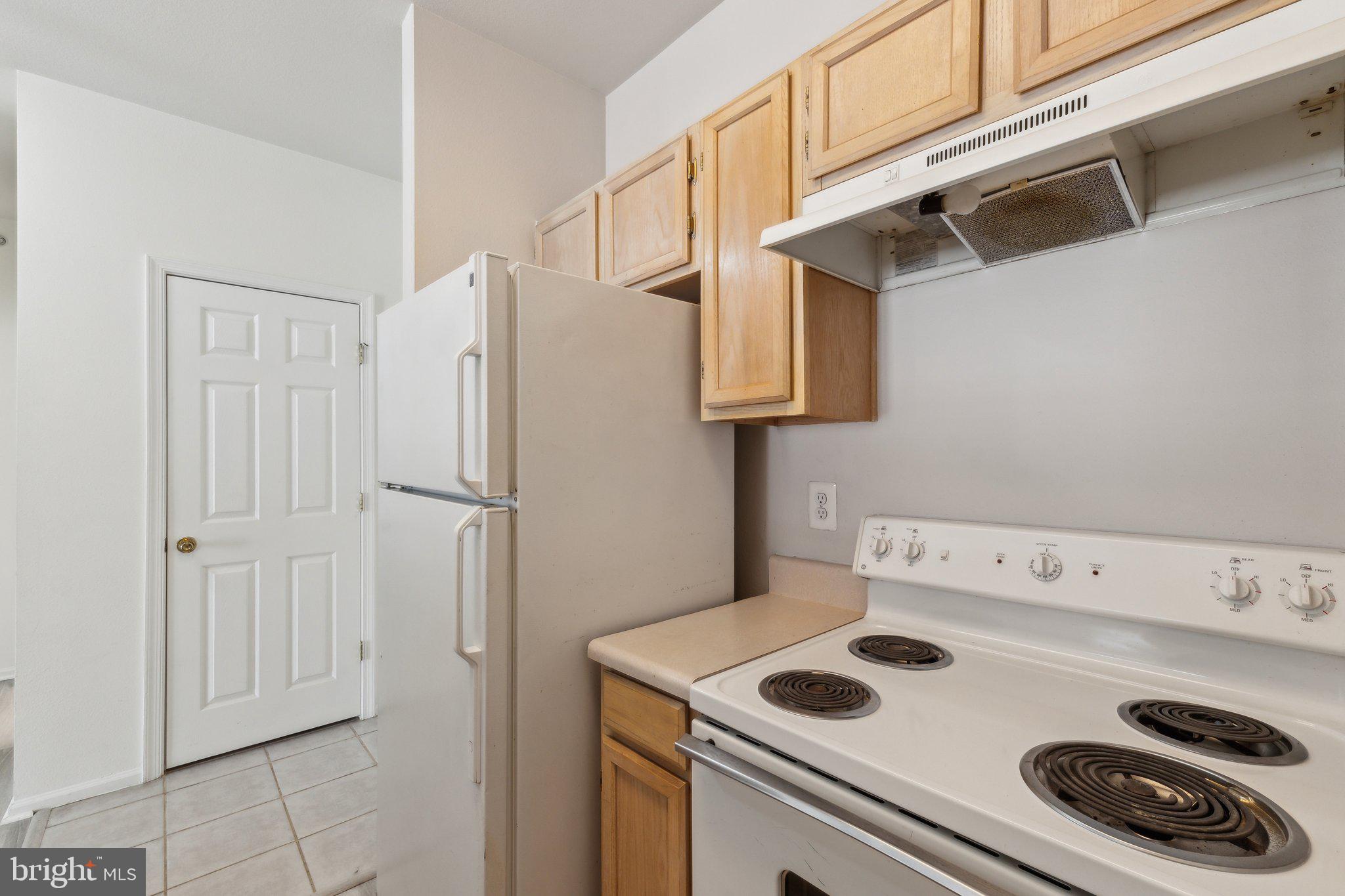 1591 Spring Gate Dr., Unit 3415 McLean, VA 22102 - Photo 10 of 20 a kitchen with a refrigerator and a stove top oven