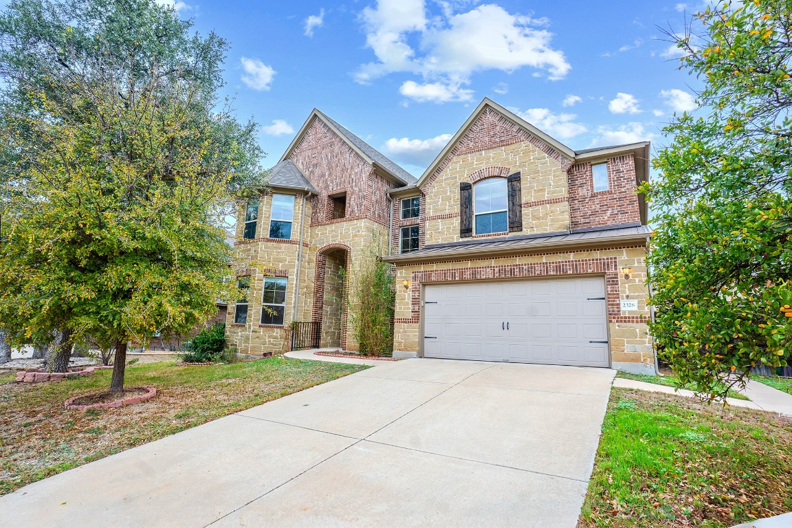 2328 Blended Tree Ranch Drive Leander, TX 78641 - Photo 2 of 30 a front view of a house with a garden and trees