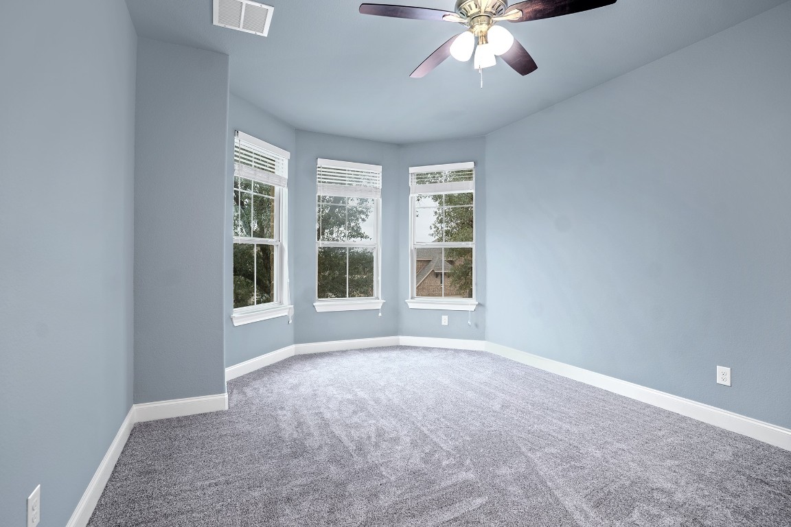 2328 Blended Tree Ranch Drive Leander, TX 78641 - Photo 26 of 30 an empty room with chandelier fan and windows