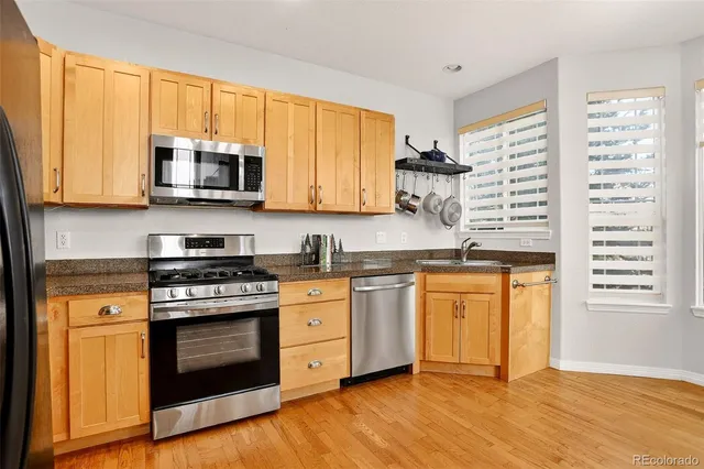 a kitchen with stainless steel appliances granite countertop a stove a sink and a microwave
