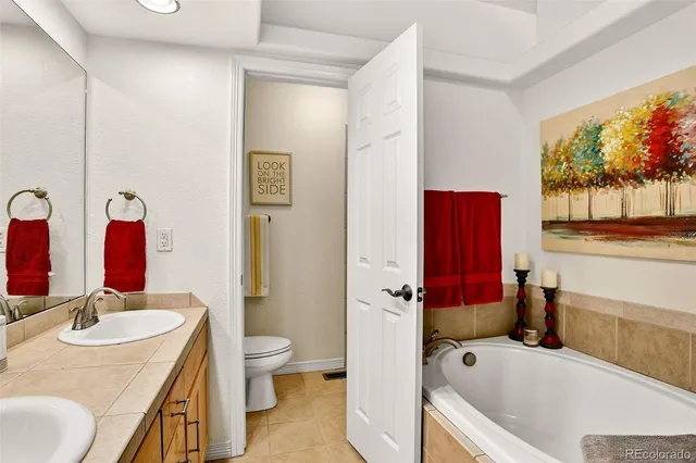 a bathroom with a granite countertop tub sink and mirror