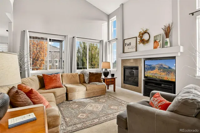a living room with furniture fireplace and a large window