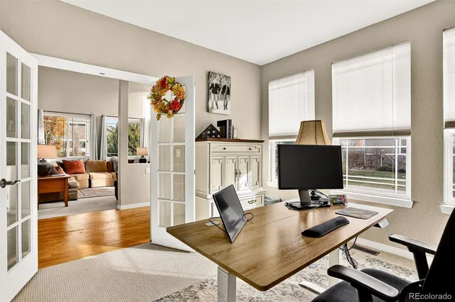 a view of a livingroom with workspace and a window
