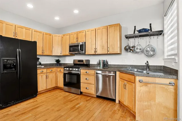 a kitchen with granite countertop a refrigerator stove top oven and sink