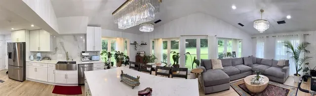 a living room with fireplace furniture and a chandelier