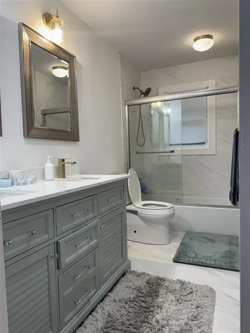 a bathroom with a toilet sink and mirror