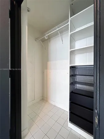 a view of walk in closet with empty racks