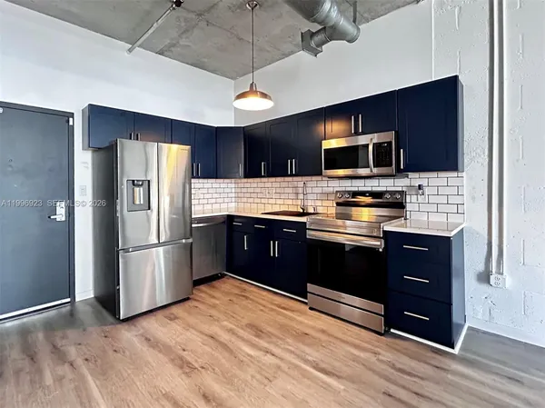 a kitchen with stainless steel appliances granite countertop a refrigerator and a stove top oven