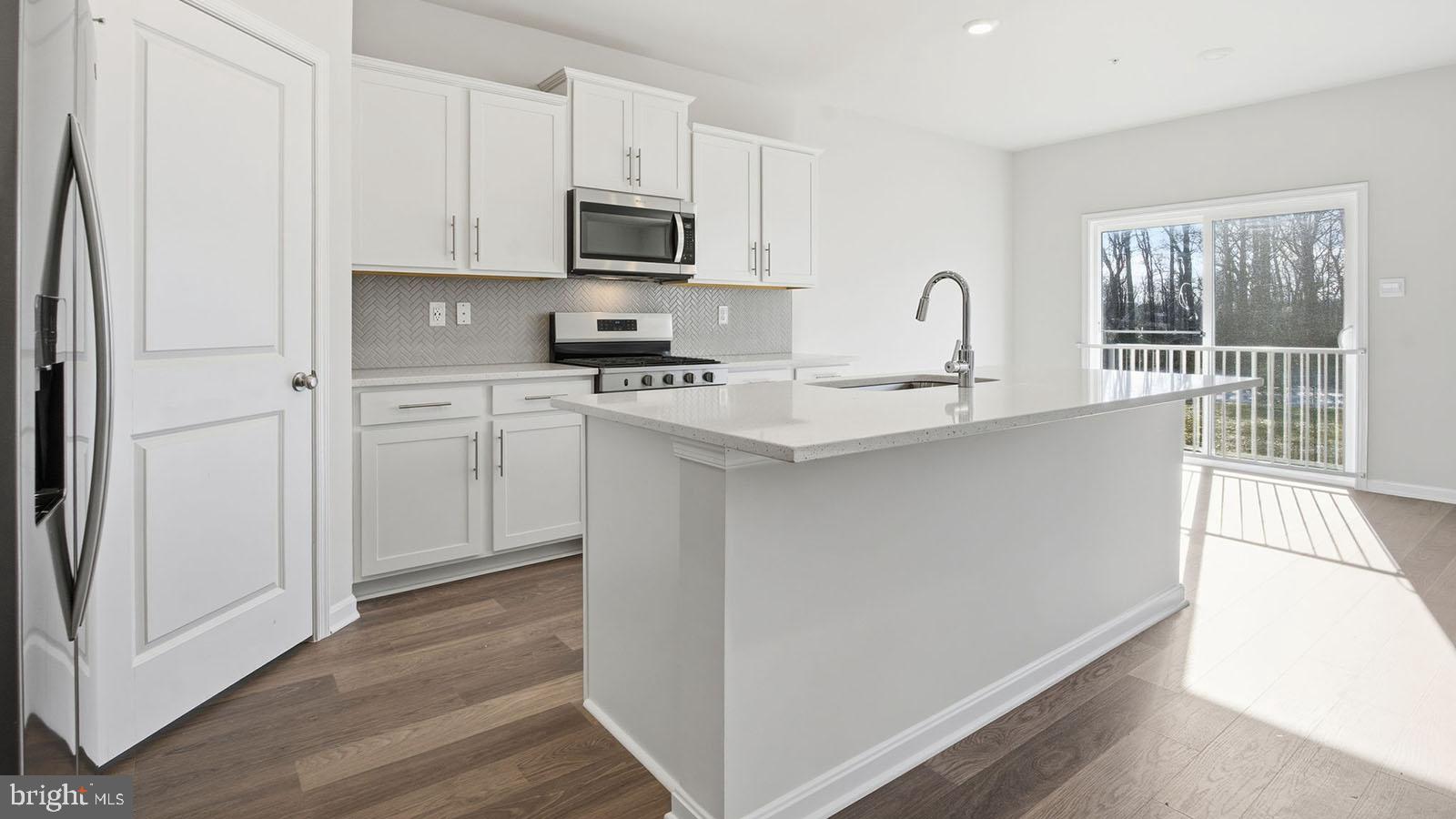 8110 Cypress Pt Drive Rosedale, MD 21237 - Photo 4 of 37 a kitchen with stainless steel appliances granite countertop a refrigerator a stove a sink and white cabinets with wooden floor