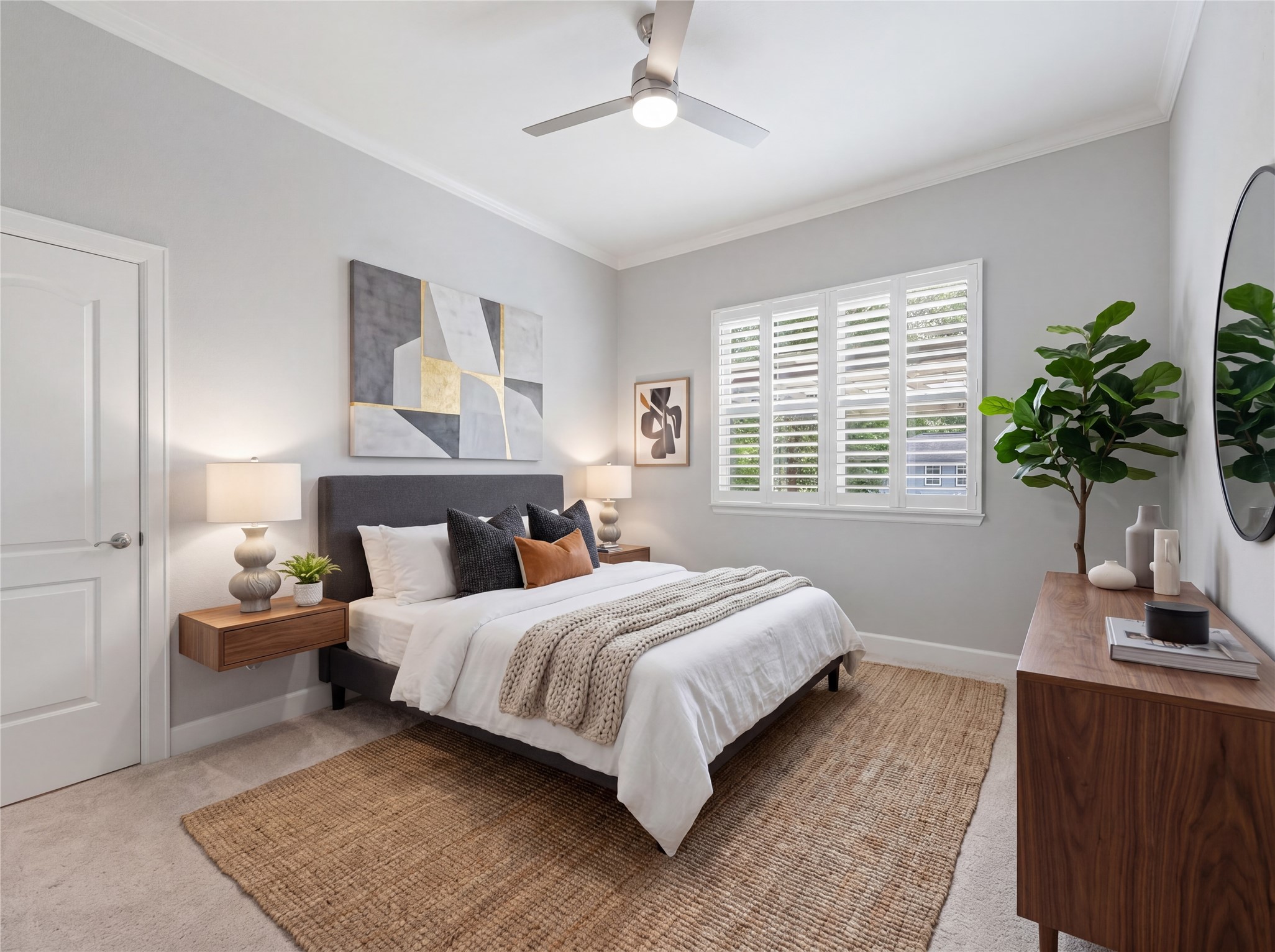 7106 Hampton Court Spring, TX 77389 - Photo 14 of 31 Guest bedroom is bright and modern, featuring a comfortable bed with stylish pillows, neutral walls, and a large window with shutters. It includes a ceiling fan, wooden furniture, and decorative plants, creating a cozy and inviting atmosphere. (virtually staged)