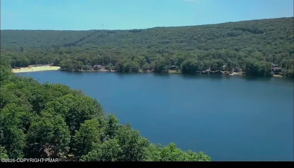an aerial view of lake and residential houses with outdoor space