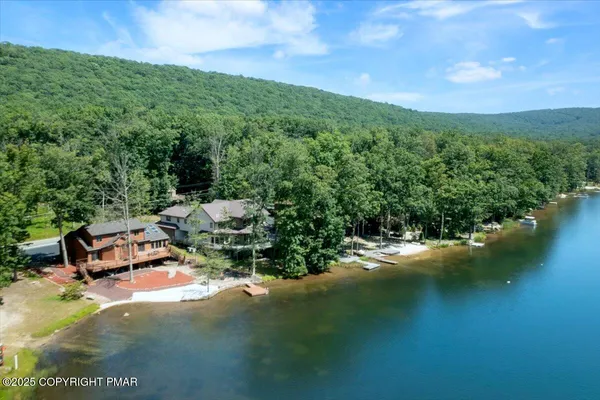 an aerial view of a house with a yard and lake view
