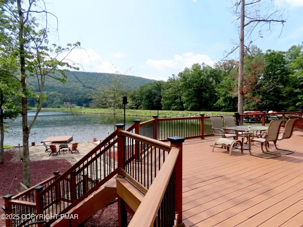 a lake view with a bench and trees in the background