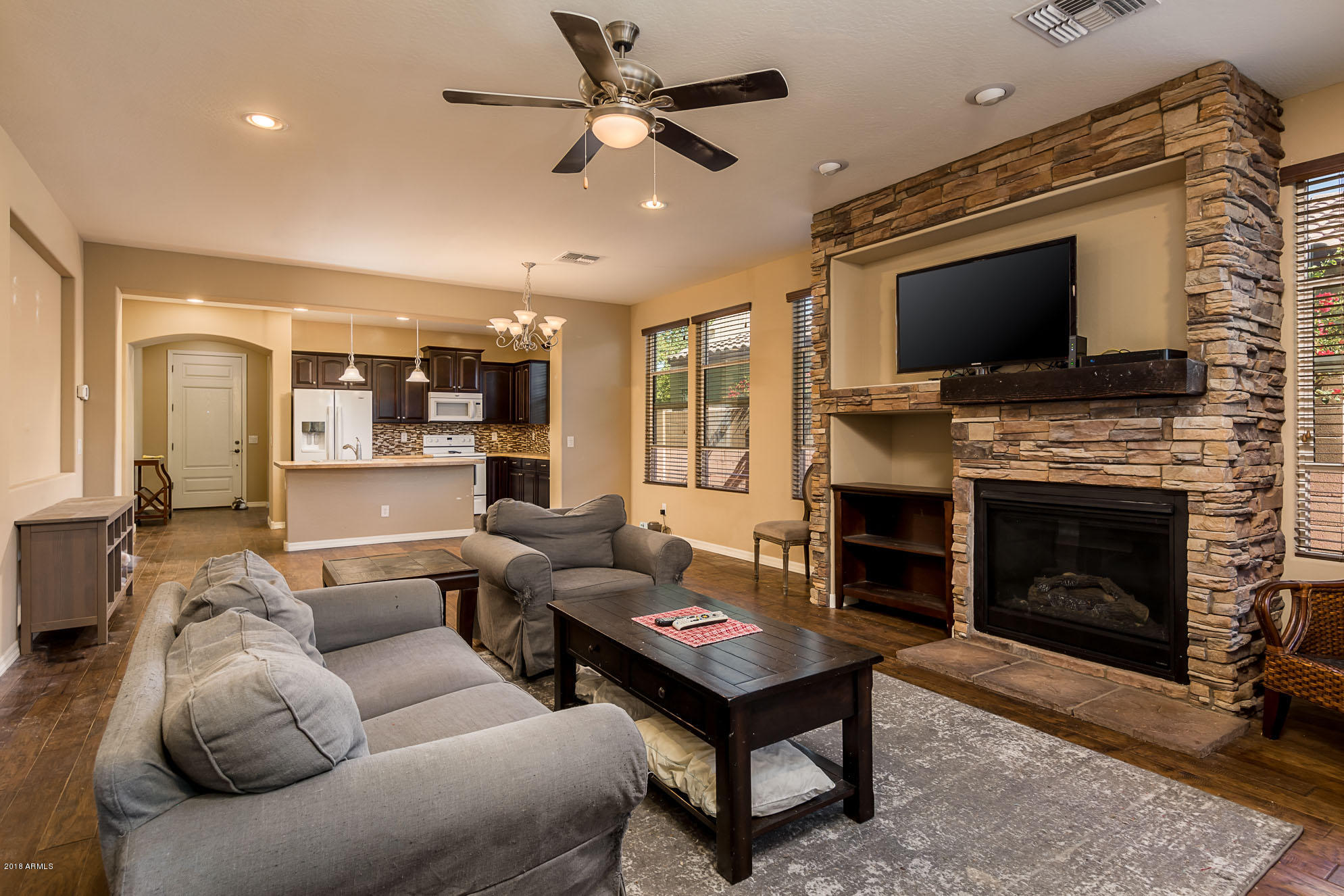 20705 West Ridge Road Buckeye, AZ 85396 - Photo 14 of 26 a living room with furniture a flat screen tv and a fireplace