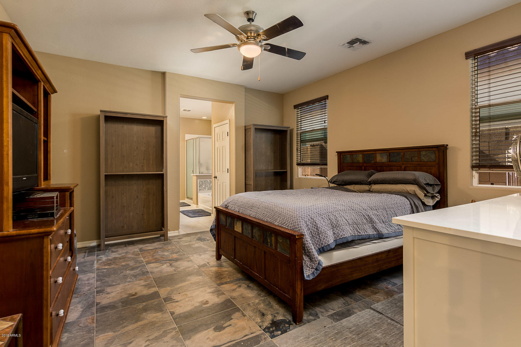20705 West Ridge Road Buckeye, AZ 85396 - Photo 16 of 26 a spacious bedroom with a bed and a chandelier