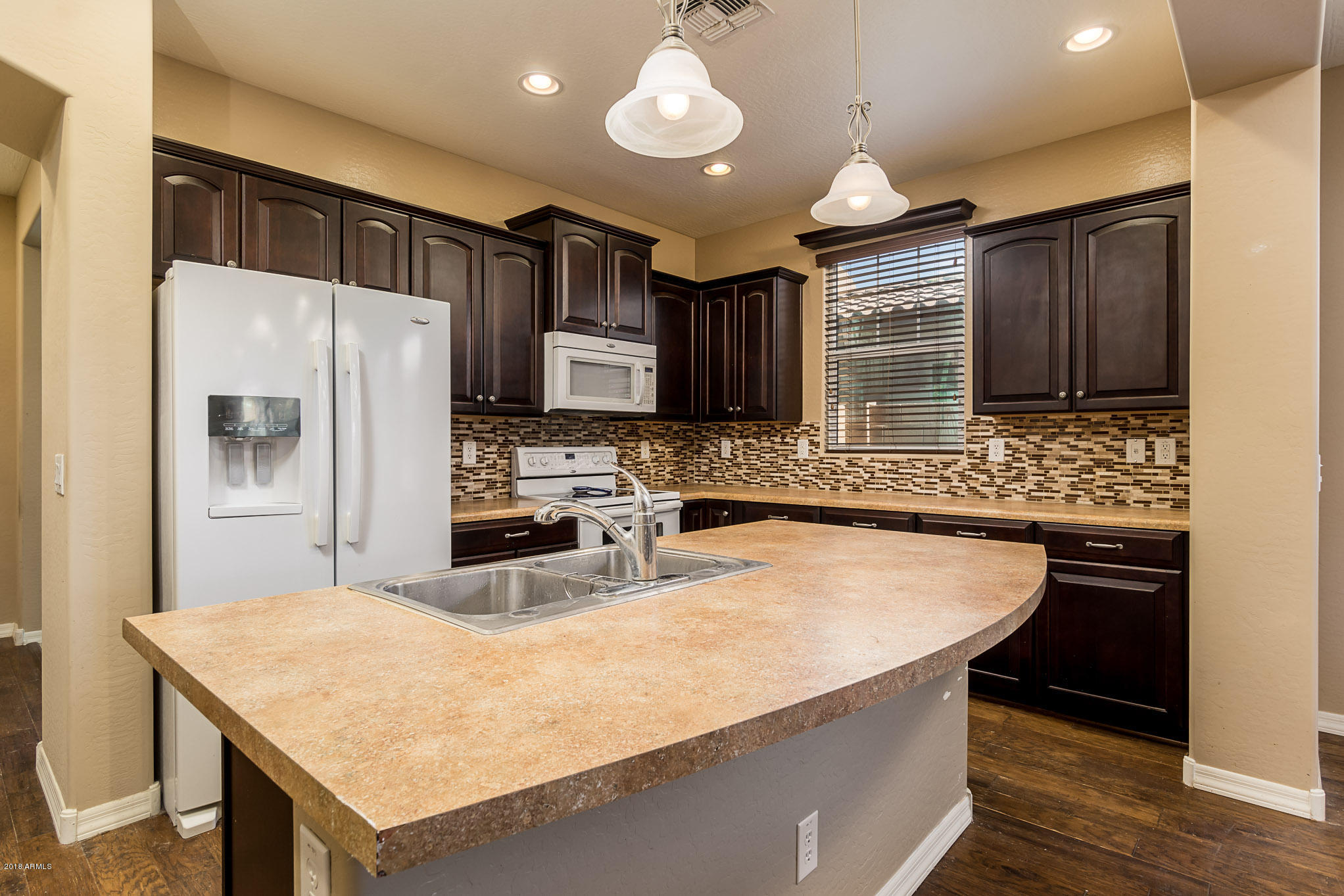 20705 West Ridge Road Buckeye, AZ 85396 - Photo 7 of 26 a kitchen with kitchen island granite countertop a sink stove and refrigerator