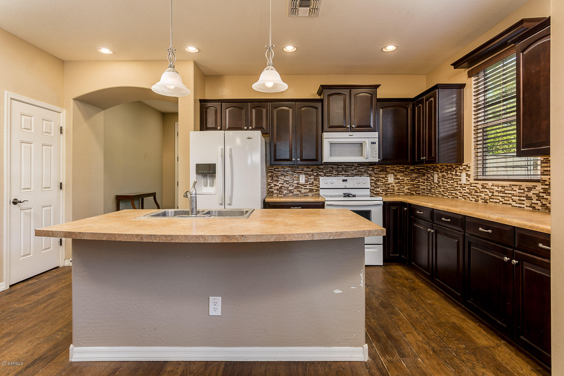 20705 West Ridge Road Buckeye, AZ 85396 - Photo 8 of 26 a kitchen with kitchen island granite countertop a sink stainless steel appliances and cabinets