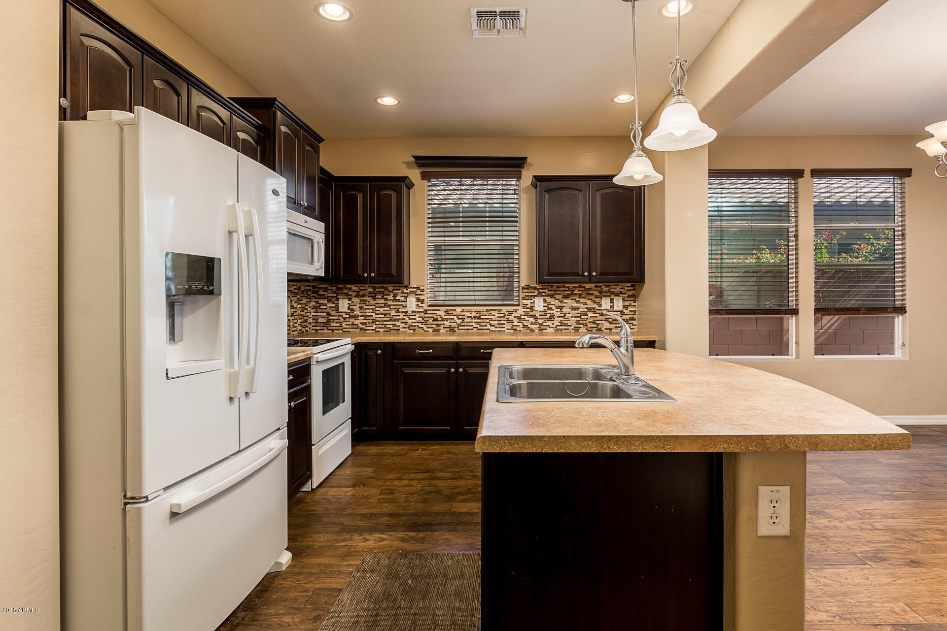 20705 West Ridge Road Buckeye, AZ 85396 - Photo 9 of 26 a kitchen with stainless steel appliances kitchen island granite countertop a refrigerator and a stove top oven