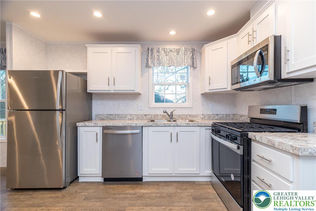 465 Royal Manor Road, Unit LOT 1 Easton, PA 18042 - Photo 3 of 15 a kitchen with stainless steel appliances granite countertop a stove a refrigerator a sink a microwave and cabinets