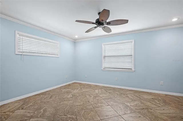a view of a big room with wooden floor and windows
