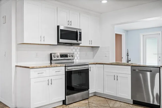 a kitchen with white cabinets stainless steel appliances and sink