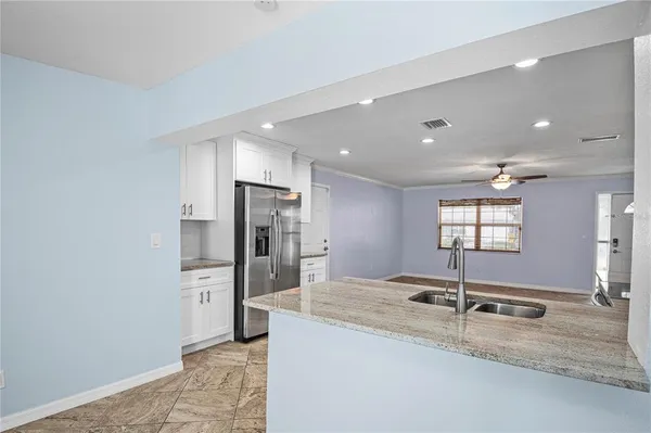 a kitchen with stainless steel appliances granite countertop a sink and a refrigerator