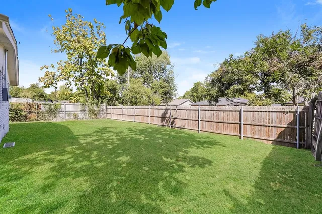 a view of yard with grass and a fence