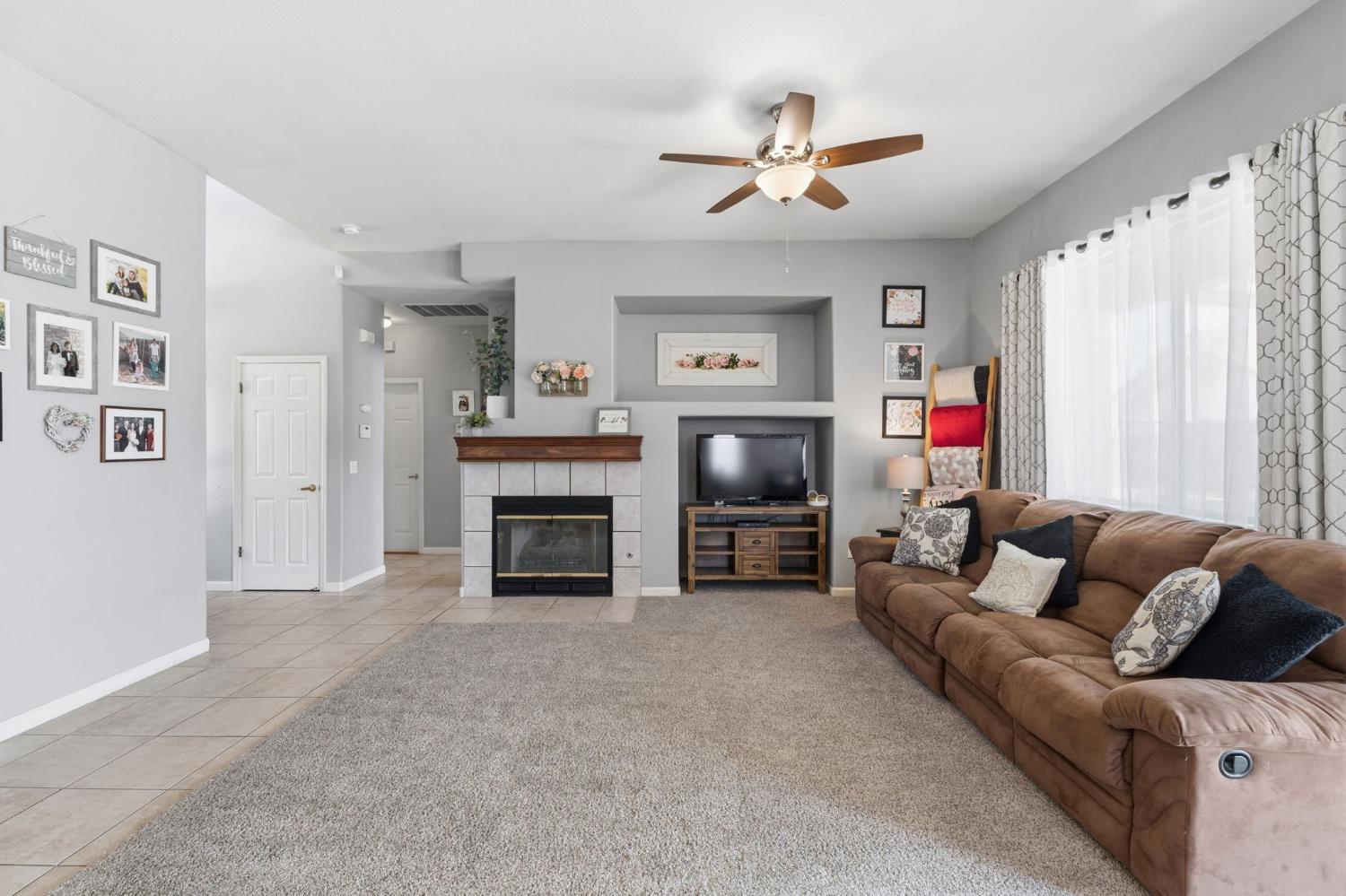1757 Homestead Way Lemoore, CA 93245 - Photo 7 of 35 a living room with furniture a fireplace and a flat screen tv