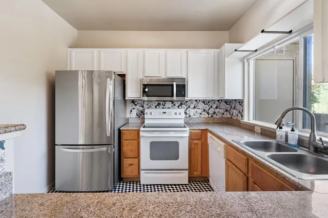 a kitchen with stainless steel appliances a refrigerator sink and microwave