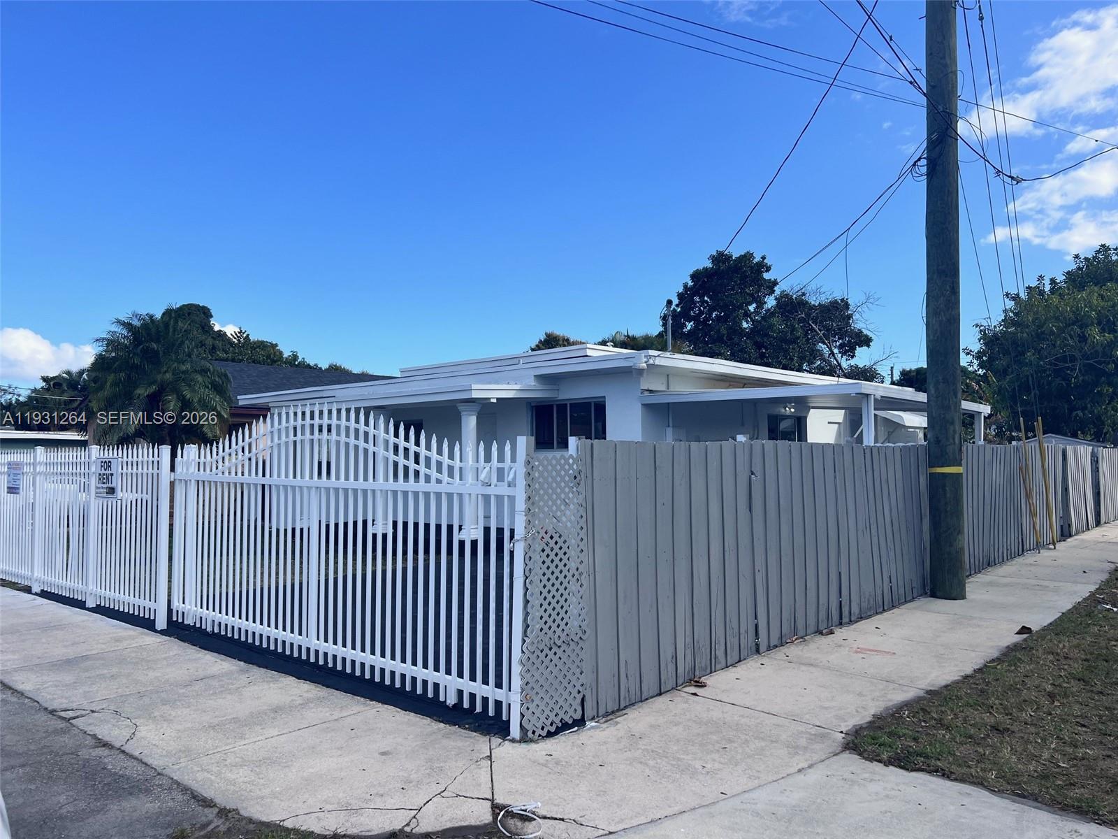 3090 Northwest 29th Street, Unit A Miami, FL 33142 - Photo 2 of 8 a view of a house with a wooden fence