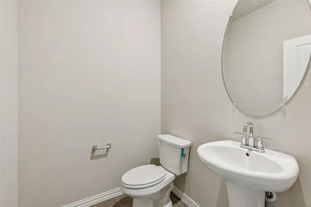 a bathroom with a sink a toilet and mirror