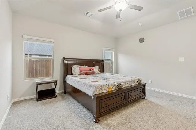 a bedroom with a bed and a chandelier fan