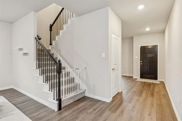 a view of a hallway with wooden floor and staircase