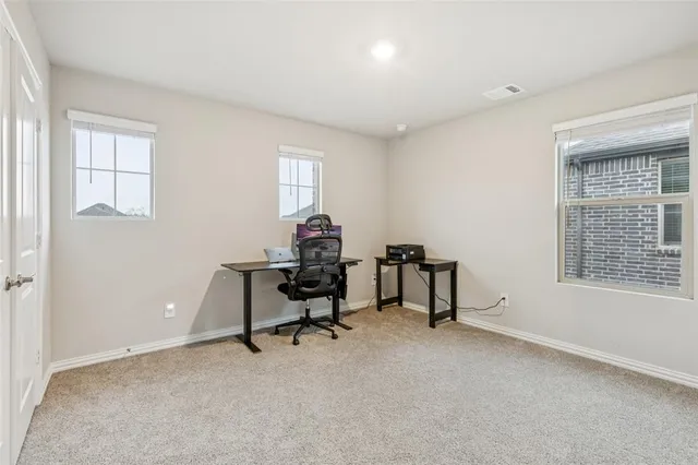 a view of a workspace with furniture and a window