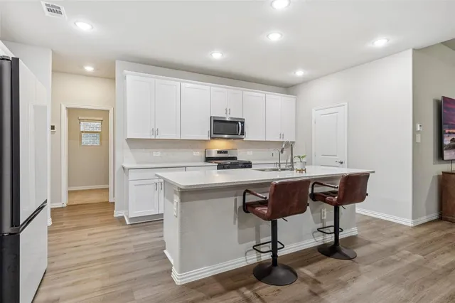 a kitchen with a sink cabinets and wooden floor