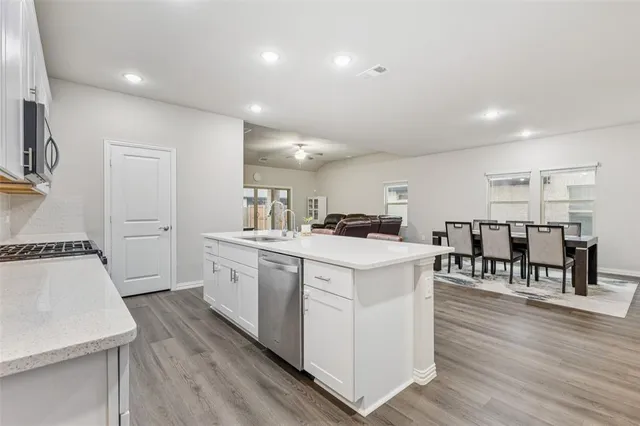 a kitchen with white cabinets and sink