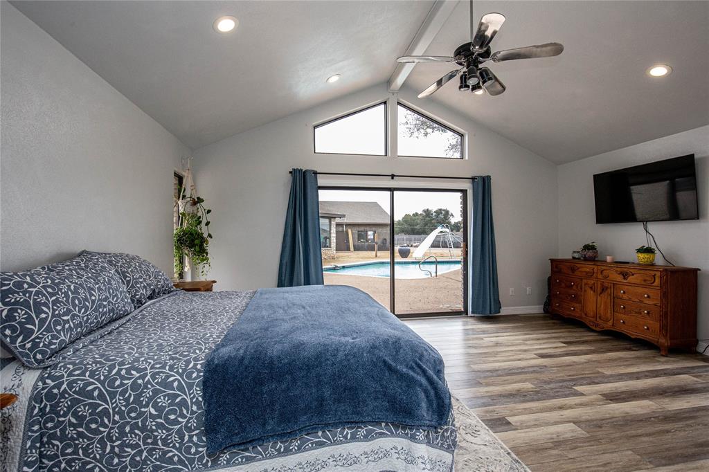 735 Willow Grove Road Woodway, TX 76712 - Photo 14 of 39 a spacious bedroom with a bed and a flat tv screen on dresser