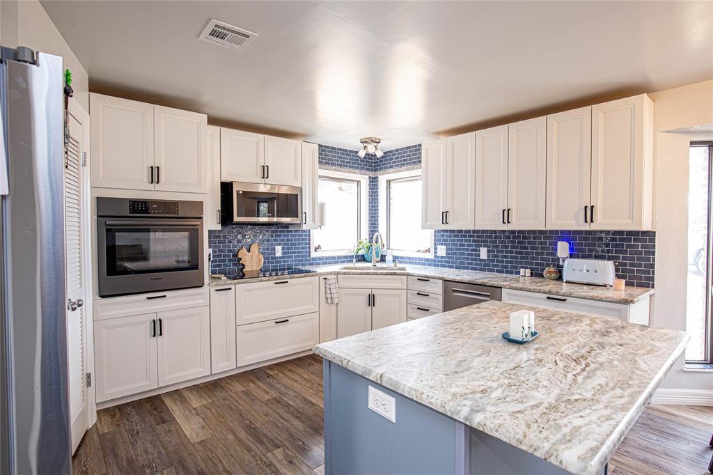 735 Willow Grove Road Woodway, TX 76712 - Photo 6 of 39 a kitchen with a sink a stove top oven and white kitchen
