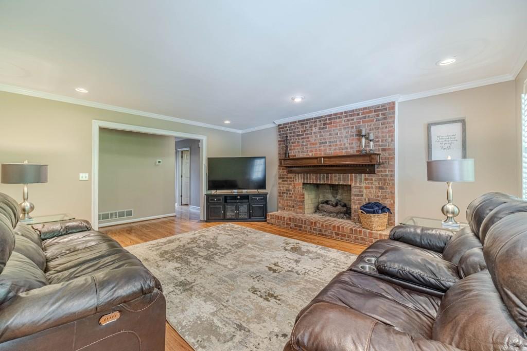 816 McDaniel Street Monroe, GA 30655 - Photo 12 of 52 a living room with furniture a fireplace and a flat screen tv