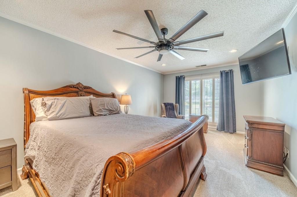 816 McDaniel Street Monroe, GA 30655 - Photo 27 of 52 a bedroom with a large bed and a chandelier