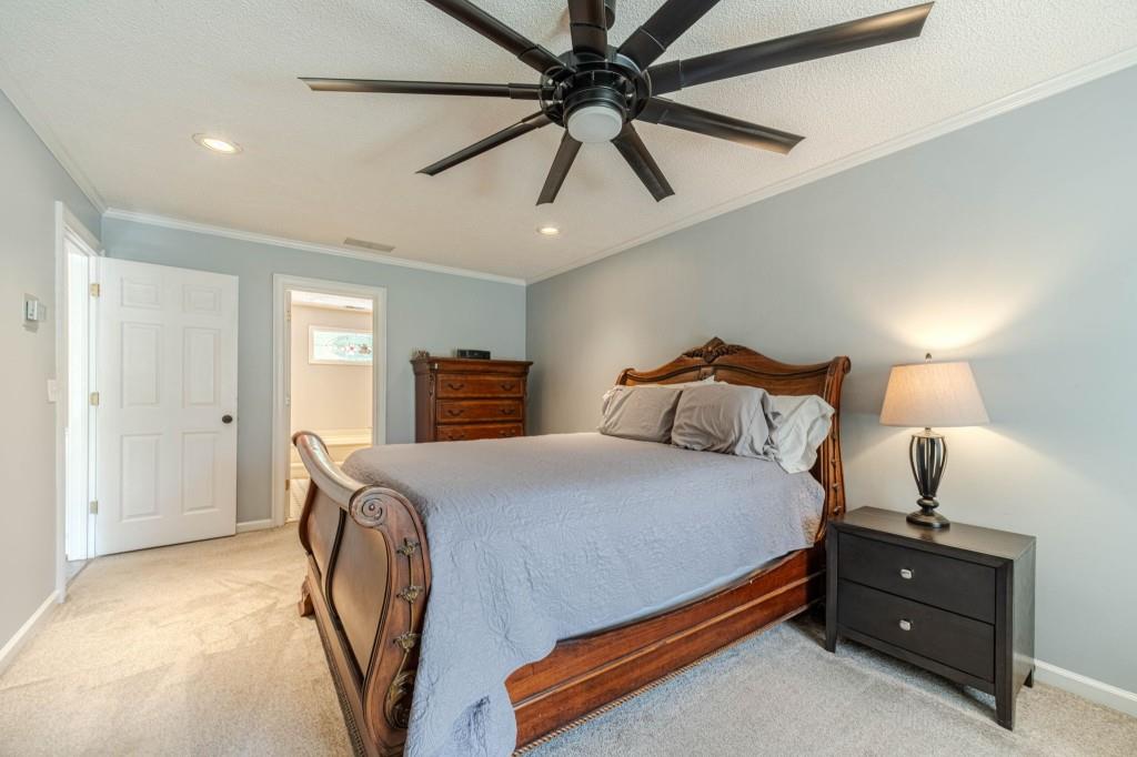816 McDaniel Street Monroe, GA 30655 - Photo 28 of 52 a bedroom with a bed and a chandelier